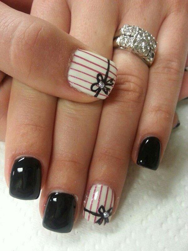 Pretty striped black and white nail art design. Make your nail art stand out with glitter stripes and a thin black ribbon painted across the...