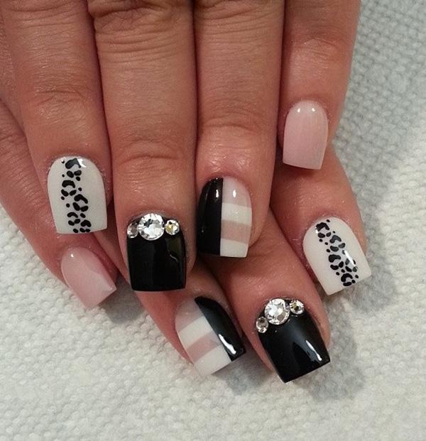 Black and white leopard nail art design with hints of nude nail polish.  The striped designs look perfect with the combination of the colors...
