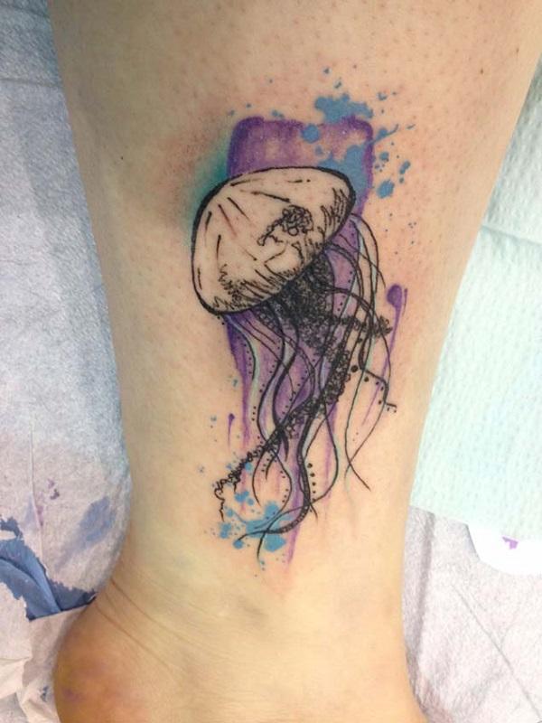 Very pretty jellyfish tattoo on the ankle.  The jellyfish is drawn in line art style while the background is an explosion of colors highligh...