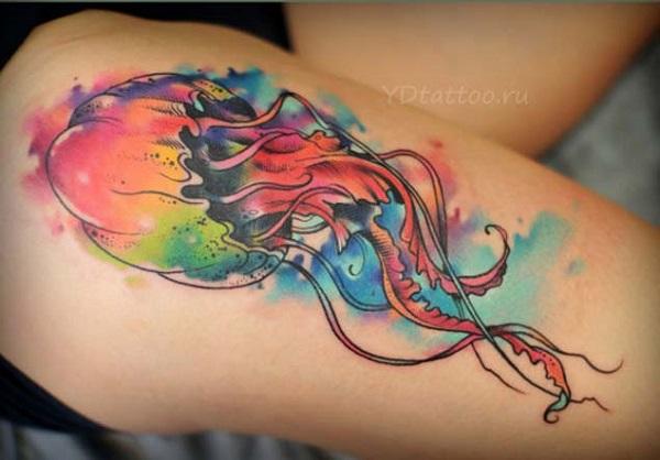Multi colored jellyfish tattoo on the thigh. The jellyfish looks absolutely stunning with the blast of colors that stem from the body of the...