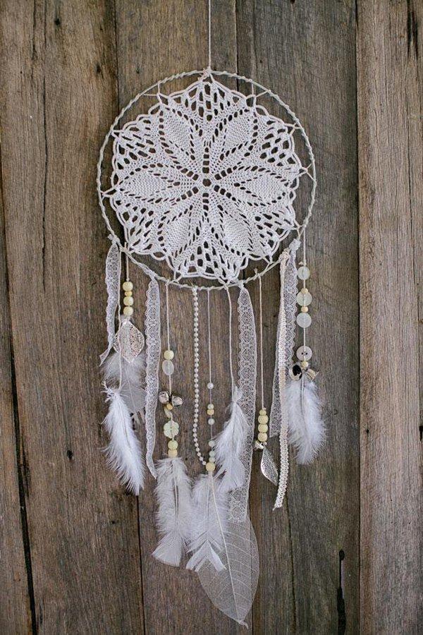 This one has a sleek and elegant design; from the crocheted string in the center to the white laces, buttons, beads and fluffy white feather...