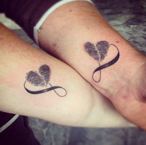 Beautiful infinity shaped couple tattoos. The infinity looping symbol is also accompanied by a heart shaped thumbprint which makes the desig...