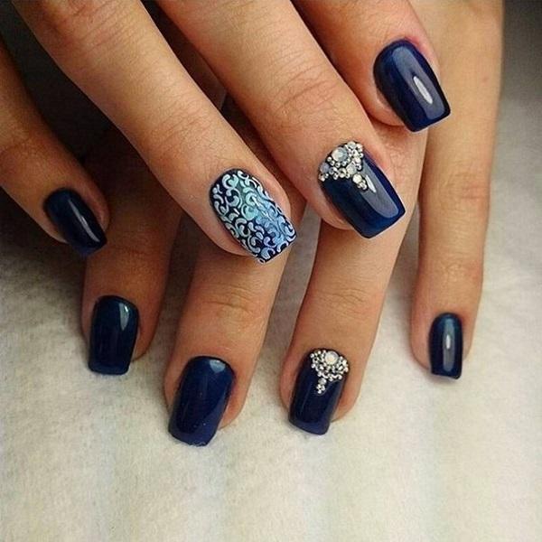 Elegant looking dark blue nail art design.  You can see that there are tribal inspired designs that are added on top in white polish to make...