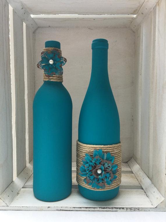 Teal chalk painted wine bottles with twine and metal flowers