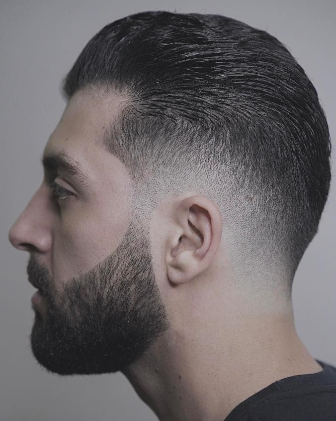 Low drop fade with everything styled slicked back-man hairstyle