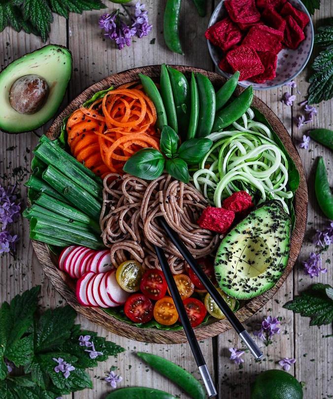 Buddha bowl loaded with wholegrain spelt spaghetti, zoodles, coodles, sugar snap peas, tomatoes, avocado, radishes, spring onion + sesam dre...