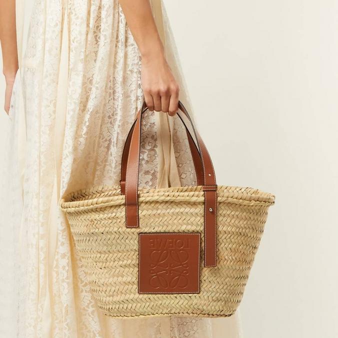 ロエベ x Paula's Ibiza スモールアナグラムイラカパームバスケットバッグ（ナチュラル/タン）。クラシックな手織りのボディ、管状のカーフスキンストラップ、刺繍されたカーフスキンのアナグラムを備えた伝統的なバスケットバッグ。 