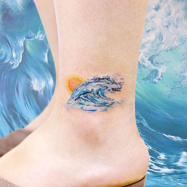 Watercolor wave and sun tattoo on ankle