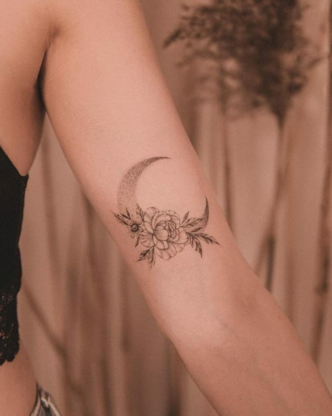 Crescent Tattoo with flowers on the upper arm female