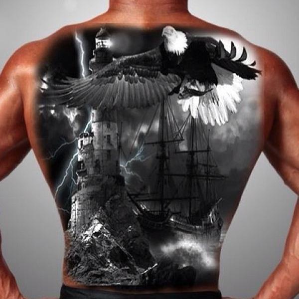 Realistic tattoo depicting a thunderous night with an eagle, lighthouse and boat on the back